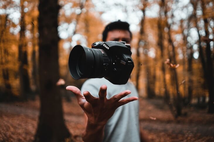 Photography - Man in the Woods Showing His Camera