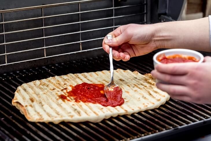 Adding Sauce to Grilled Pizza